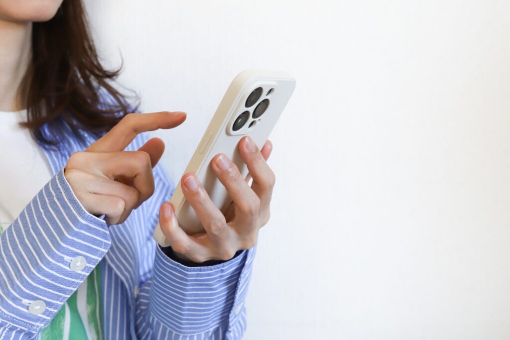 スマホを触る女性の画像