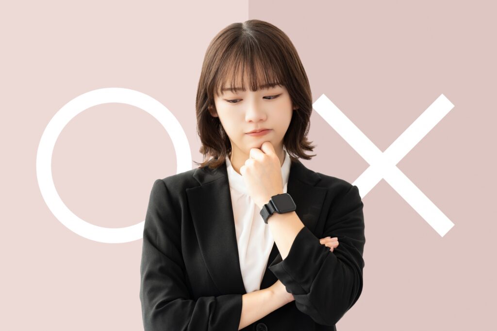 マルかバツか、どちらか考える女性の画像