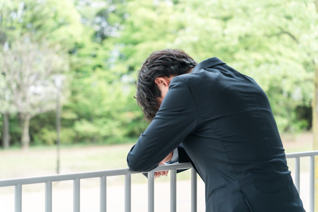 落ち込んでいるスーツの男性の画像
