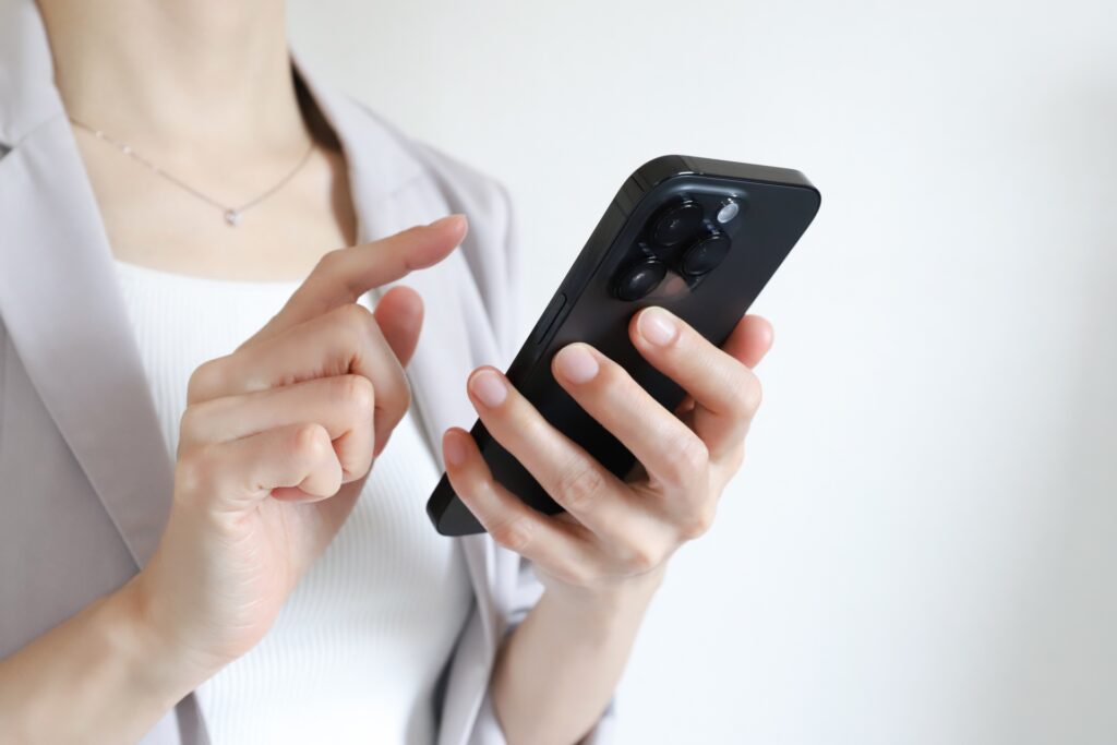 スマホを持つ女性の写真
