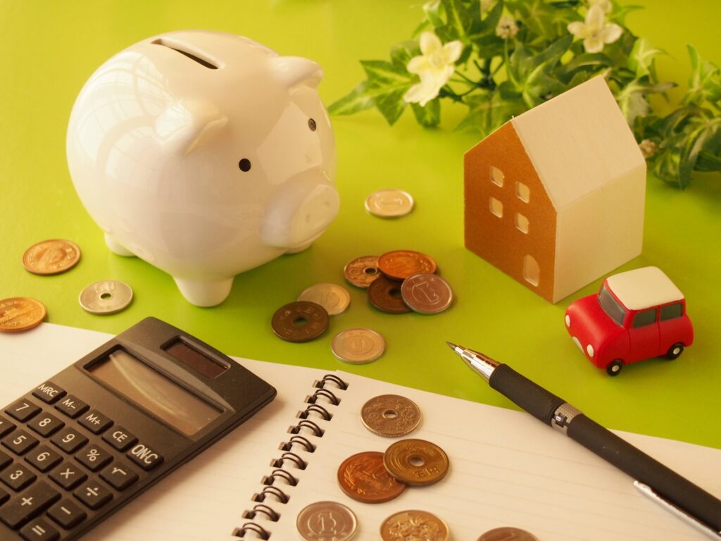 豚の貯金箱と散らかったお金の写真