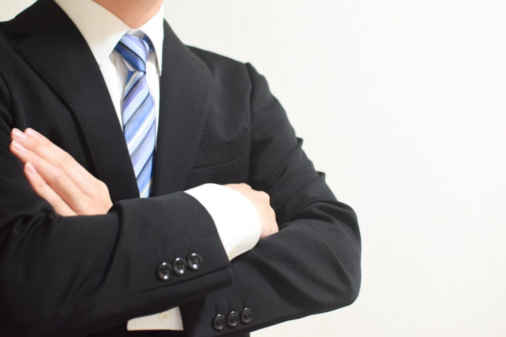 腕組みをする営業マンの画像