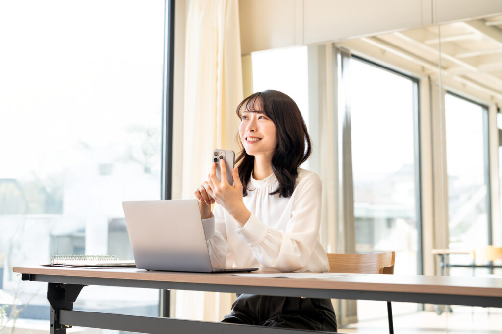 スマホを持つおしゃれな女性の画像
