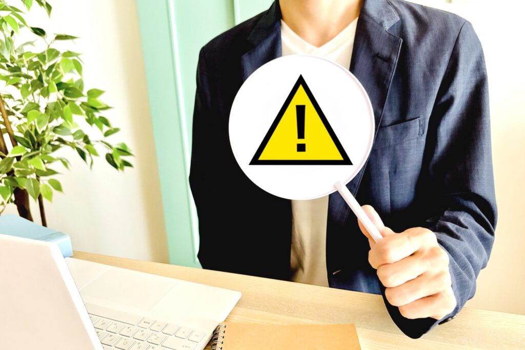 注意の札を持っている男性の写真